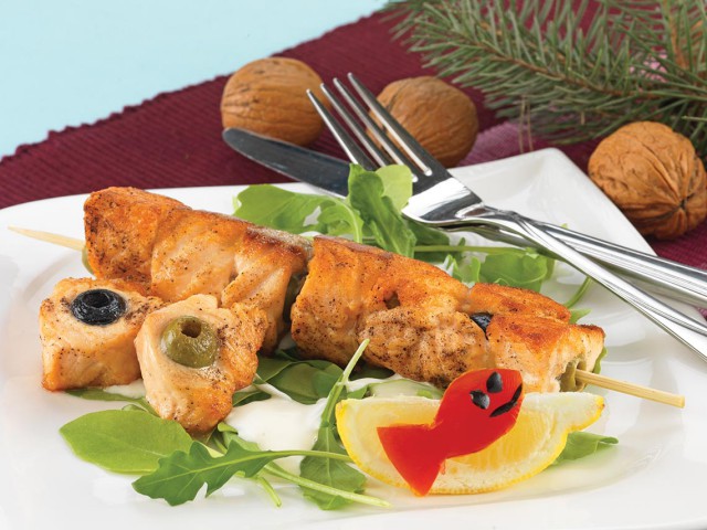 Salmon with olives on skewers, rocket salad with mayonnaise and yogurt dressing